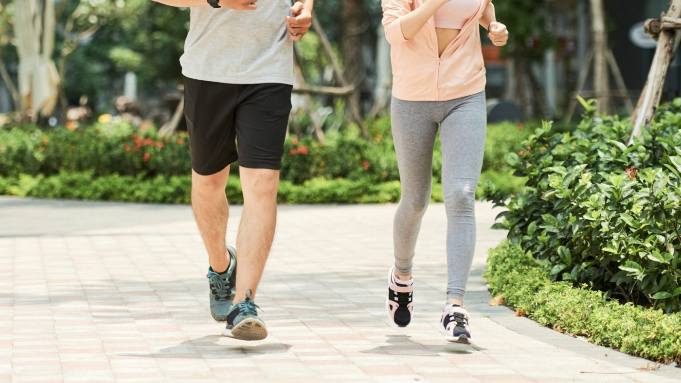 Vietnamese man and woman jogging together in the park